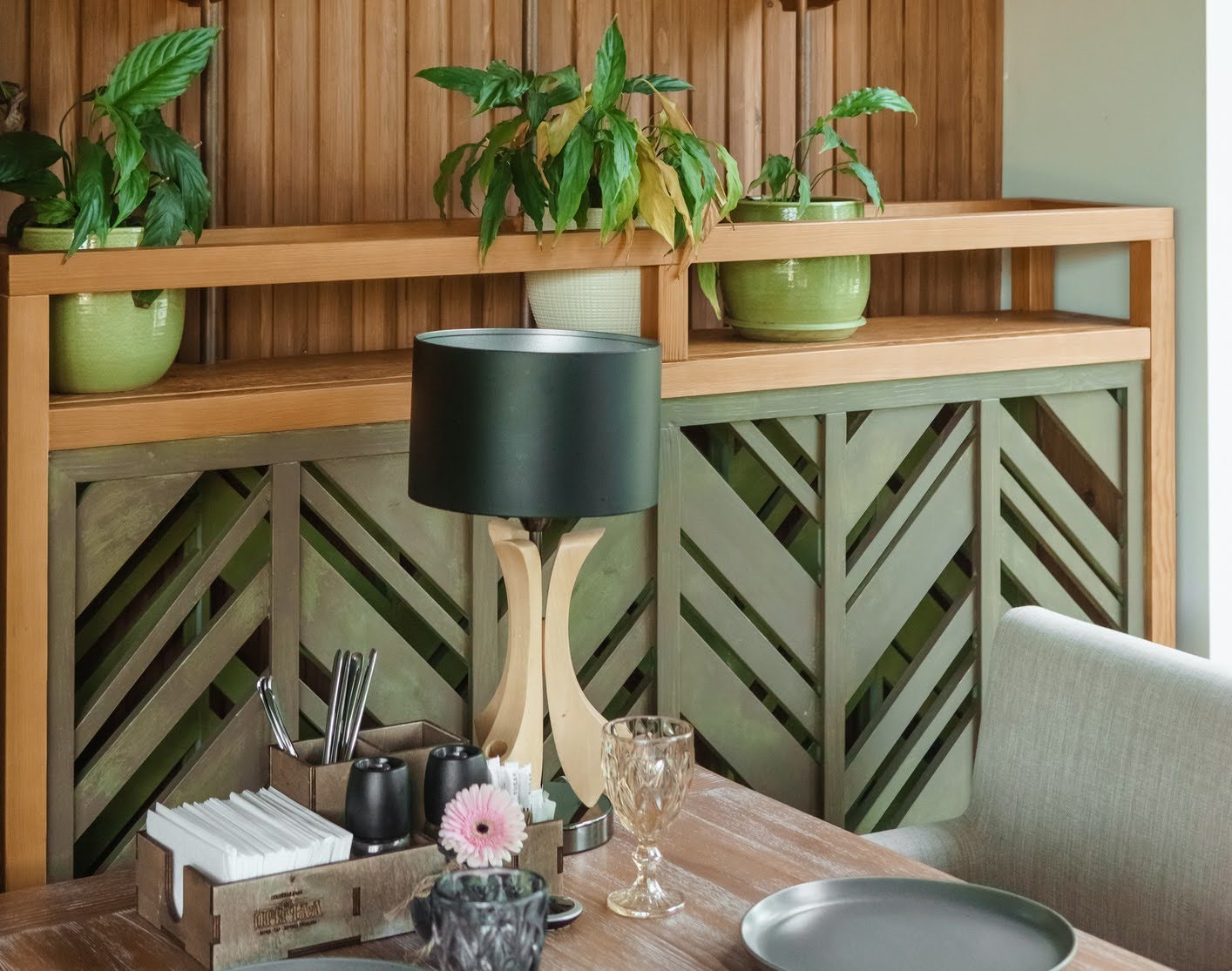 Senior living community dining table setting featuring biophilic interior design with wood paneling in organic natural pattern in background.