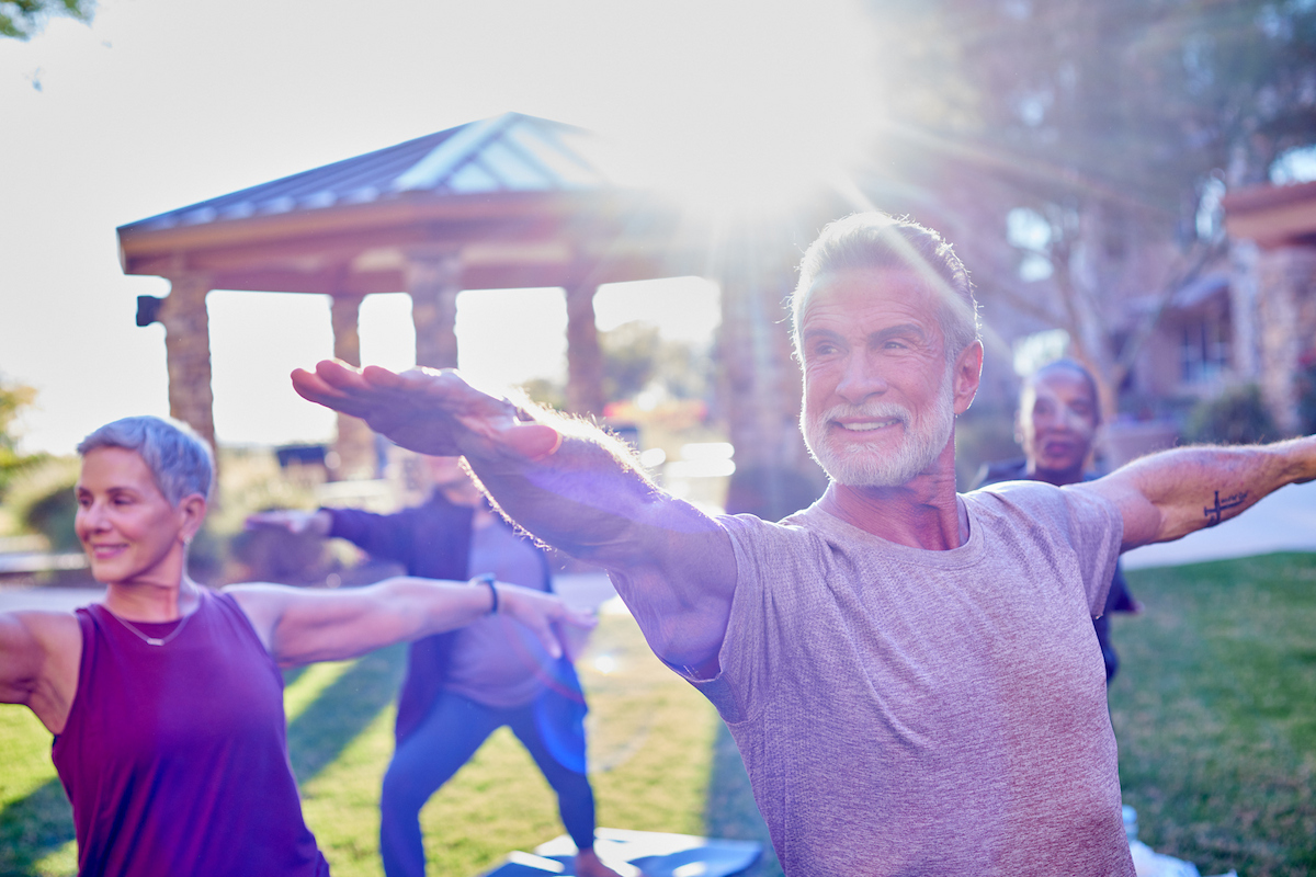 Photo of senior living community outdoor space with residents at a yoga session.